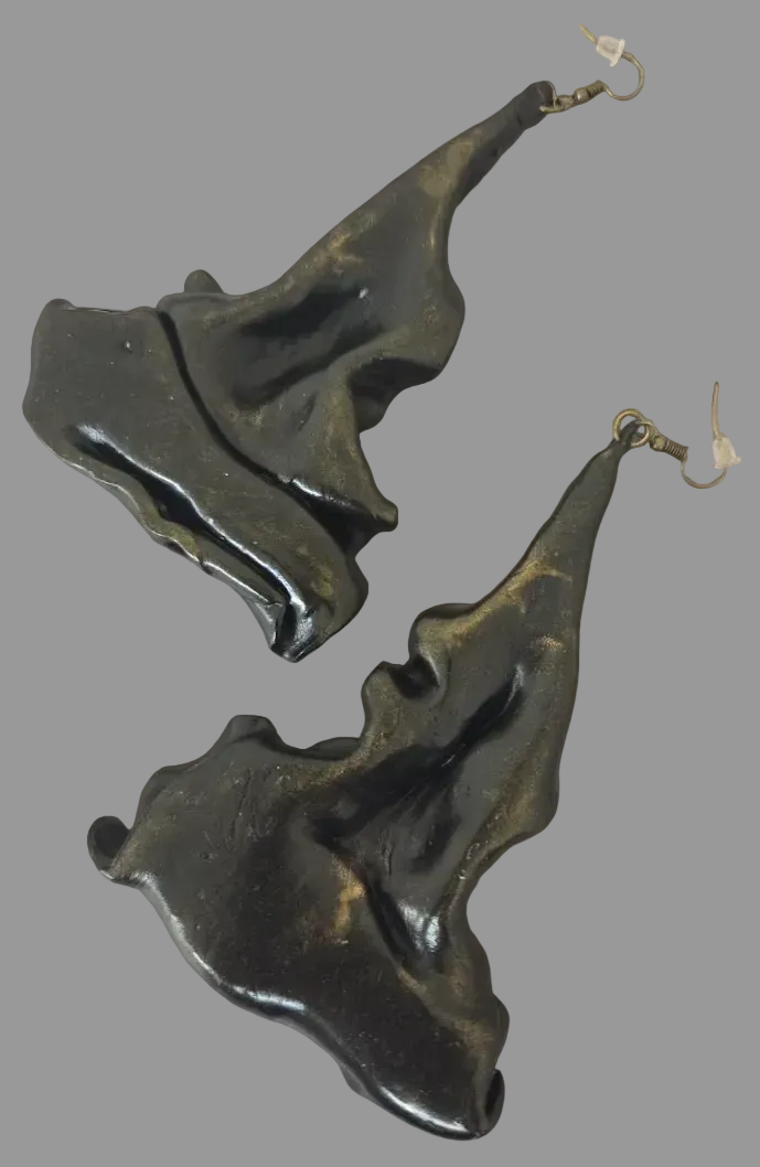 Pair of faux bronze metal hand sculpted piercedearrings on a black  background
